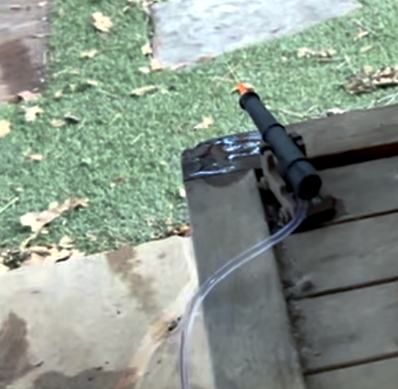 Final water-spraying turret mounted near an outdoor deck with tubing attached.